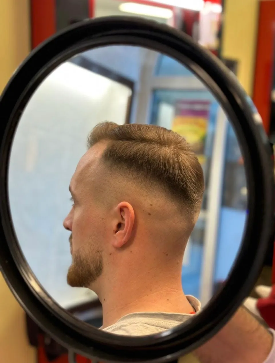Klassischer Seitenscheitel mit hohem Fade, im Handspiegel fotografiert