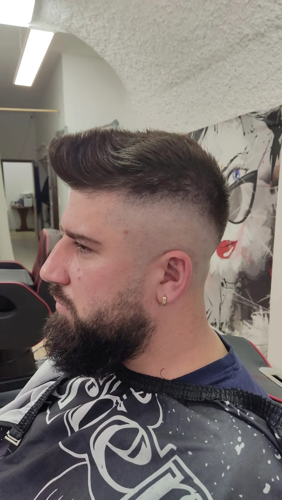 Nach oben frisierter Pompadour mit hohem Fade und konturiertem Vollbart